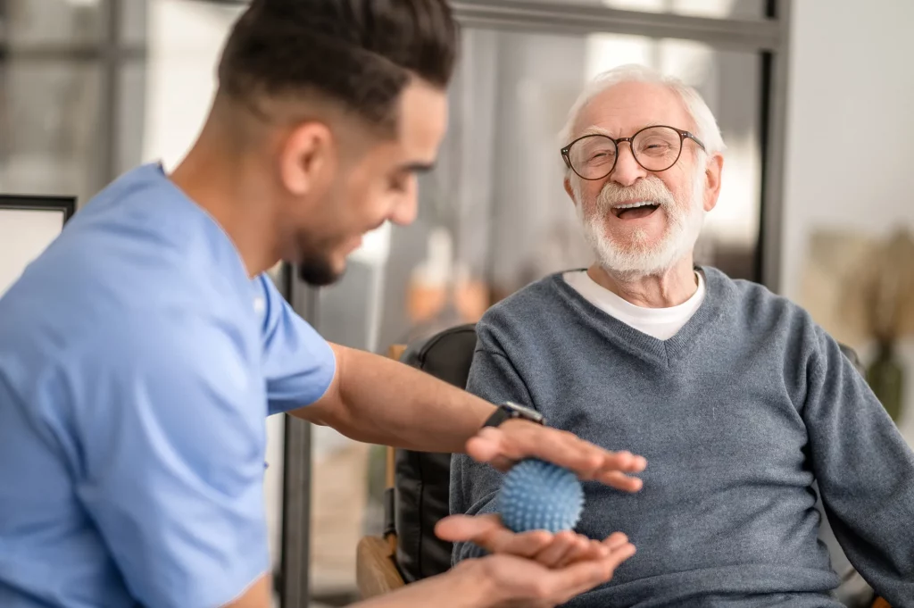Seniorin erhält therapeutische Unterstützung zur Förderung von Beweglichkeit und Selbstständigkeit.