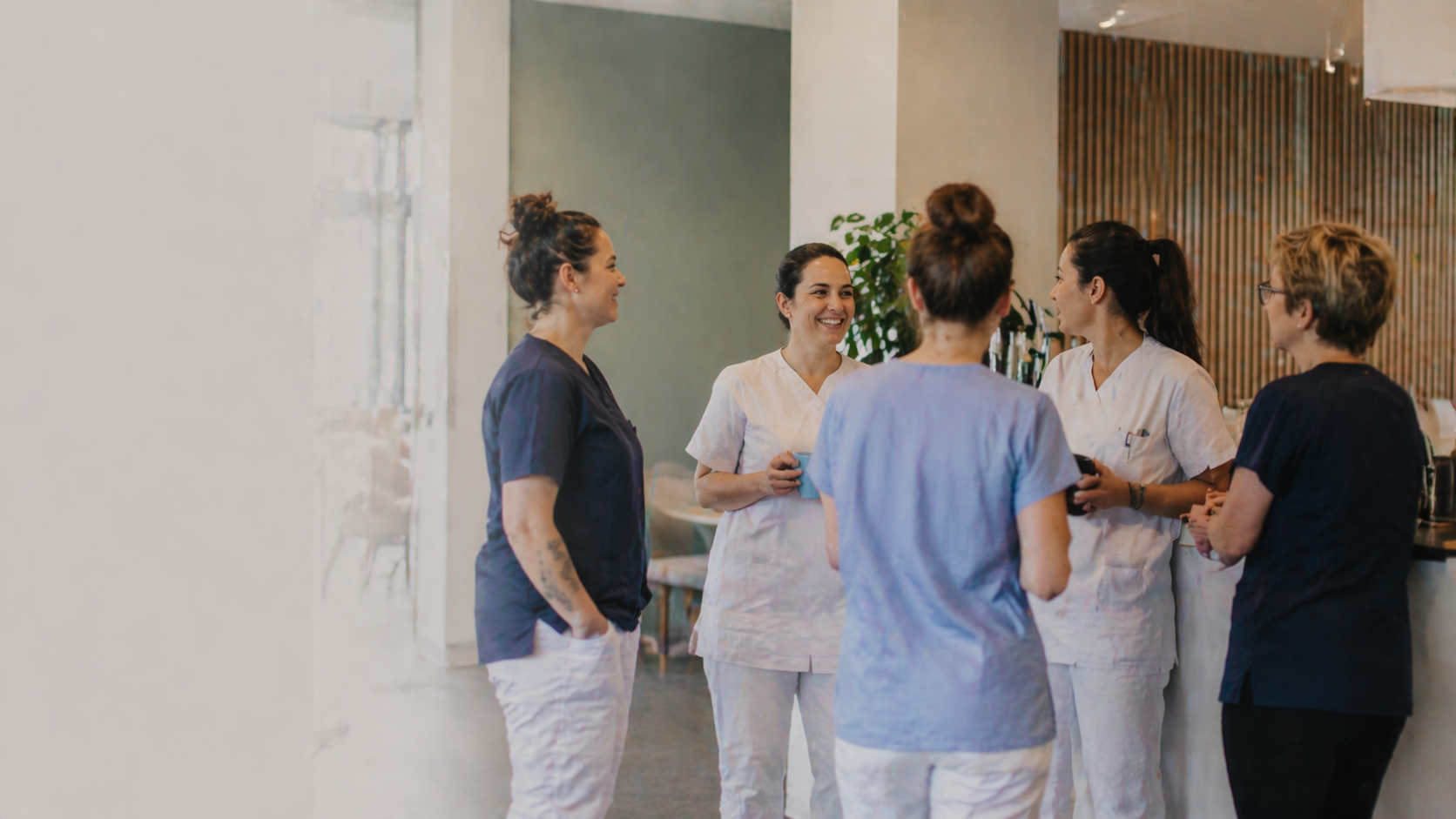 Vertrauensvolle Zusammenarbeit zwischen Pflegefachkraft, Angehörigen und Patient:innen im Alltag.