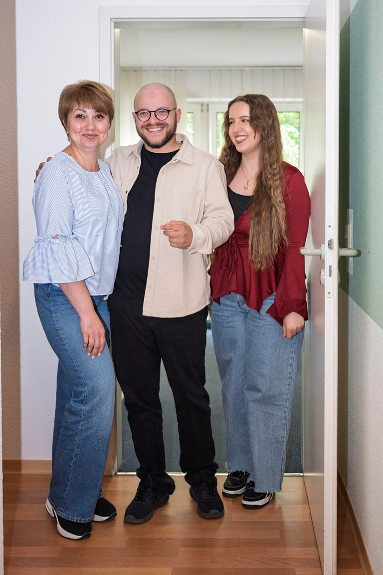 Teamfoto zu dritt in der offenen Tür.