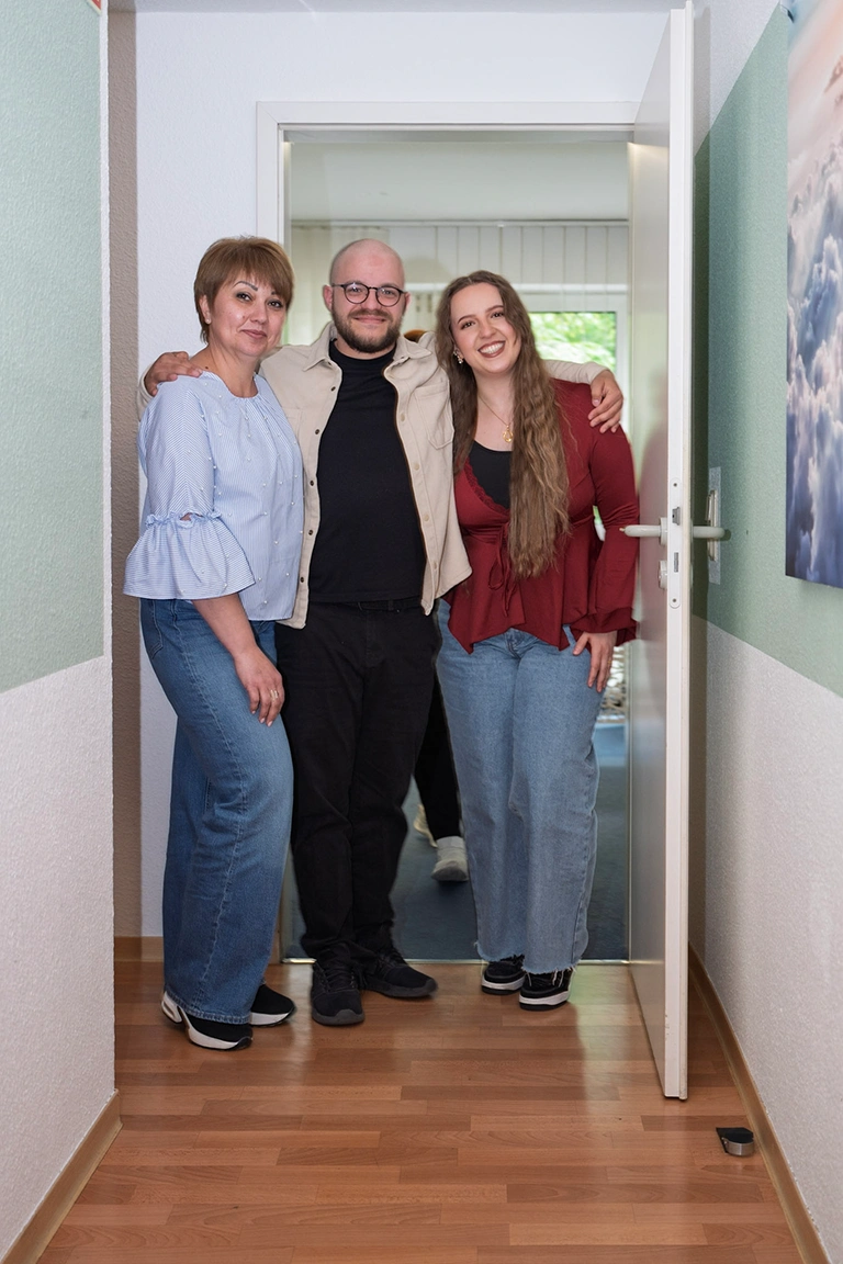 Teamfoto zu dritt in der offenen Tür.