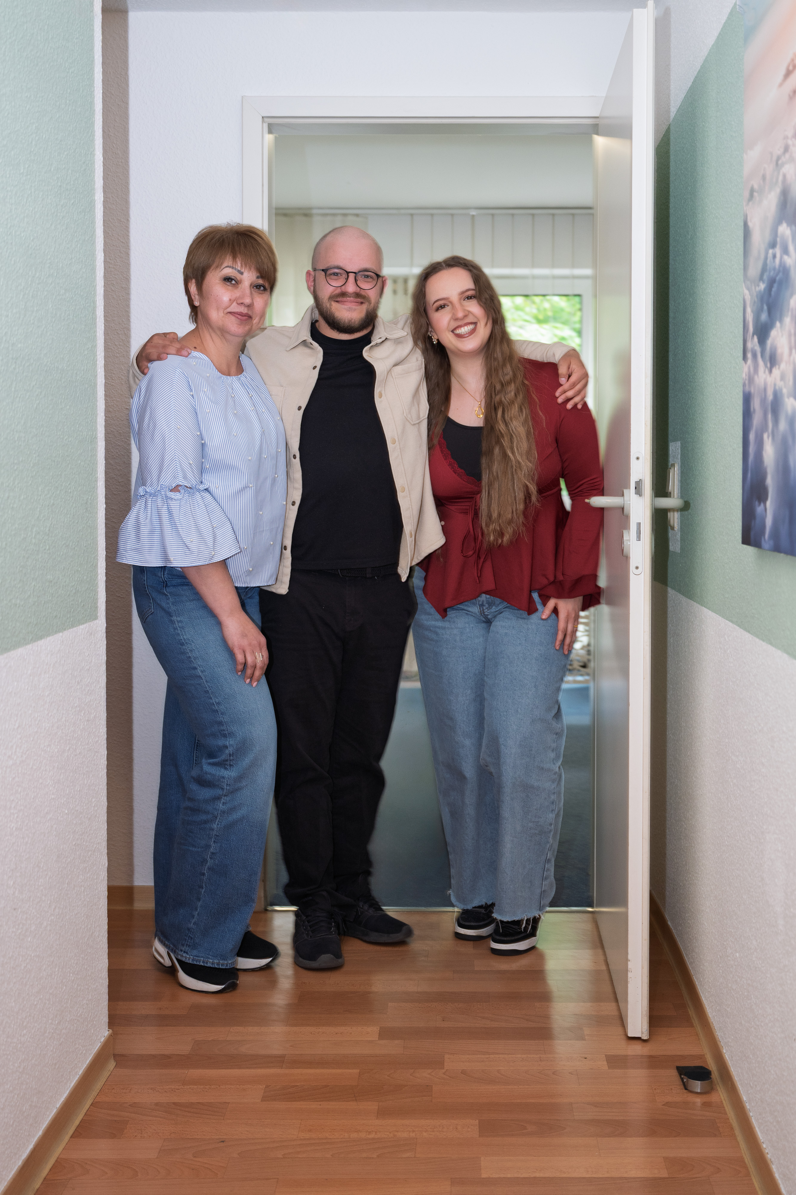 Teamfoto zu dritt in der offenen Tür.